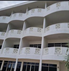 a white building with white balconies and a palm tree at New Casamarc in Bentota