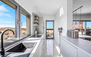 a kitchen with white counters and a large window at 3 Bedroom Amazing Apartment In Vodice in Vodice