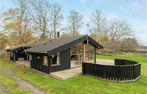 una casa negra con terraza en un campo en 3 Bedroom Cozy Home In Vejby, en Vejby