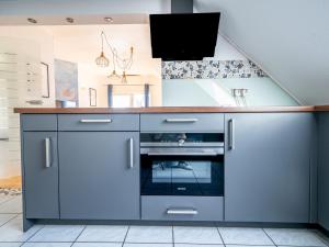 uma cozinha com armários azuis e um lavatório em Penthouse-Suite near University em Giessen