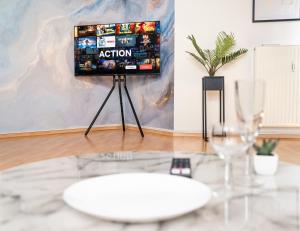 TV en un trípode en una sala de estar con mesa en Penthouse-Suite near University, en Giessen