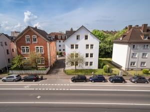 eine Stadtstraße mit Autos, die an einer Straße geparkt sind in der Unterkunft Penthouse-Suite near University in Gießen