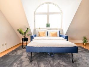 um quarto com uma cama azul e uma grande janela em Penthouse-Suite near University em Giessen