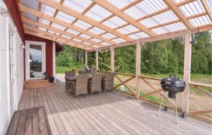 una terraza de madera con pérgola y parrilla en Beautiful Home In Lngserud With Kitchen, en Rullan