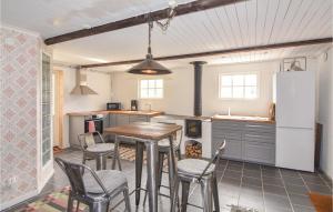 cocina con mesa, sillas y nevera en Beautiful Home In Lngserud With Kitchen, en Rullan