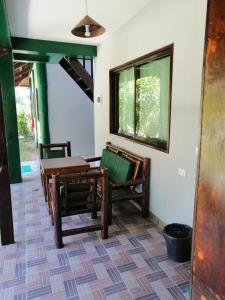 a room with chairs and a table and a window at Eddie`s Beach Resort Siargao in General Luna