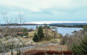 a view of a lake with a house on a hill at 3 Bedroom Stunning Home In Blomsterdalen in Blomsterdalen
