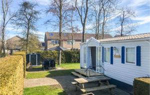 a white tiny house with a picnic table and a bench at Stunning Home In Tzummarum With Wifi in Tzummarum