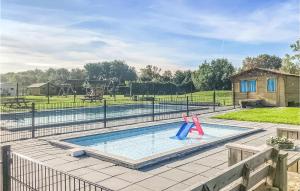a pool with two slides in it with a playground at Nice Home In Tzummarum With 2 Bedrooms, Wifi And Outdoor Swimming Pool in Tzummarum