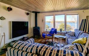 uma sala de estar com dois sofás e uma televisão em Lovely Home In Trollhttan With House Sea View em Trollhättan
