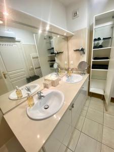 ein Badezimmer mit zwei Waschbecken und einem großen Spiegel in der Unterkunft Chambres d'hôtes du Parc Bordelais in Bordeaux