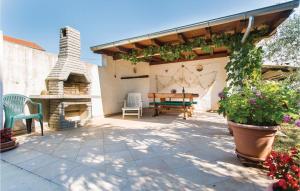 a patio with a table and a stone fireplace at Nice Apartment In Krk With Wifi in Brzac