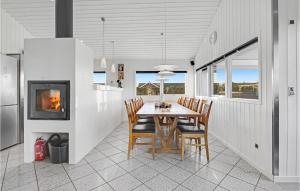 オテルプにあるAmazing Home In Otterup With 3 Bedrooms, Sauna And Wifiのダイニングルーム(テーブル、椅子、暖炉付)