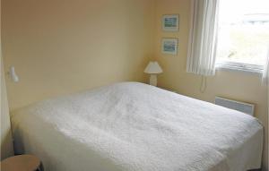 1 dormitorio con cama blanca y ventana en Martex, en Fanø
