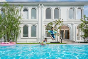 a man and a child playing in a swimming pool at Arpo Pool Villa Riverside Bangkok in Bangkok