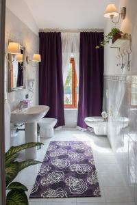 サン・ジュリアーノ・テルメにあるIl Casale Relaisのバスルーム(シンク2台、トイレ2つ、紫色のカーテン付)