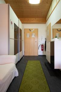 Cette chambre comprend un lit, une porte et un tapis. dans l'établissement feworld living - near Salzburg city, à Freilassing