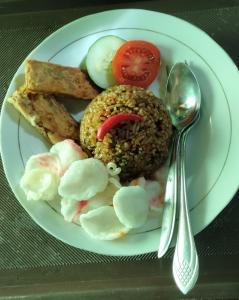 un plato de comida con arroz y verduras en una mesa en Golo Tango Homestay en Labuan Bajo