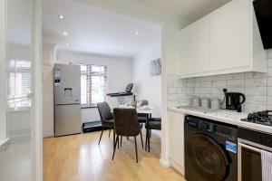 a kitchen with a washing machine and a dining room at Great Location Free Parking Contractor Leisure in Peterborough