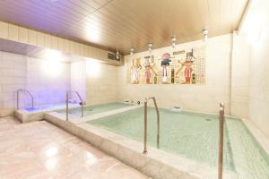 a large swimming pool in a building with at Sauna & Cabin Thermae-yu Nishiazabu in Tokyo