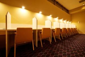 une salle de conférence avec une grande table et des chaises dans l'établissement Sauna & Cabin Thermae-yu Nishiazabu, à Tokyo