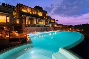 a swimming pool in front of a house at night at Chunda Shikar Oudi in Udaipur +16 photos