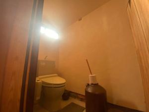a small bathroom with a toilet and a light at 古民家リトルヴィラTokorangi in Tokoname