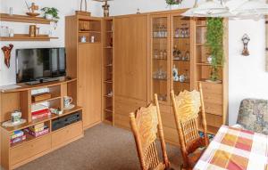 ein Wohnzimmer mit einem TV und Holzschränken in der Unterkunft Ferienhaus Am Breitenberg N in Winterstein