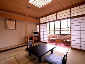 um quarto com uma mesa e cadeiras num quarto em Suikoukan em Hakone