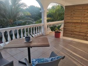 a porch with a table and chairs on a balcony at Artists house in Rivière Noire