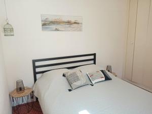 a bedroom with a bed with two books on it at Les Boramars 4 23 climatisé wifi 300m plage in Argelès-sur-Mer