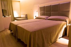 una camera con un grande letto e una sedia di Barcelona House a Barcellona