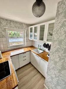 a kitchen with white cabinets and a sink and a window at RelaxStay - Balkon - Smart-TV - WIFI in Dielheim +17 photos