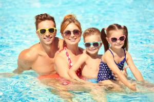 a family in the water at a swimming pool at Beautiful 8 Berth Caravan With Decking At Broadland Sands In Suffolk Ref 20017cv in Hopton on Sea