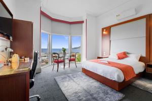 a hotel room with a bed and a desk and chairs at Oakleigh House in Burnie