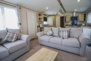 a living room with two couches and a kitchen at Beautiful 6 Berth Caravan With Decking At Southview Holiday Park Ref 33024o in Skegness