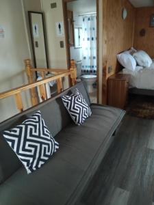 a couch with two pillows on it in a room at Cabañas Quito in Compu