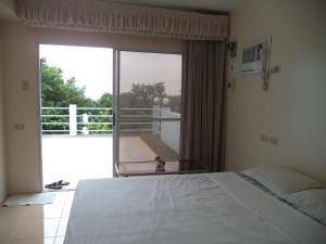 a bedroom with a bed and a view of a balcony at High Steps Pension in Catmon