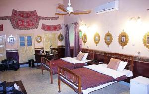a bedroom with two beds and a ceiling fan at Bhairon villas in Bikaner