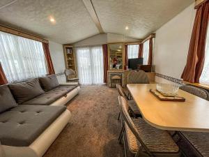 a living room with a couch and a table at Caravan At Highfield Grange With Decking, Sleeps 6 Ref 26446ba in Clacton-on-Sea