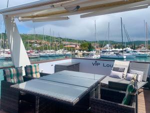 een tafel en stoelen op het dek van een boot bij BellaVista HouseBoat Apartment Portorose in Portorož