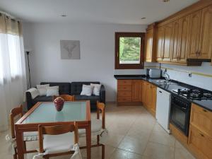 a kitchen with a table and a living room at CAL JAN - SOLANA in Bellver de Cerdanya