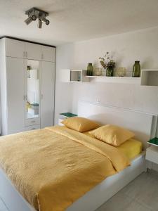 um quarto com uma cama com um cobertor amarelo em Opal em Muralto