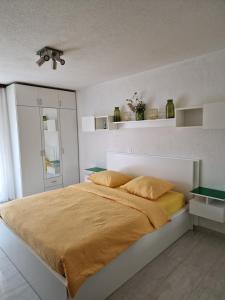um quarto com uma cama grande com lençóis amarelos em Opal em Muralto