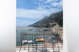 uma varanda com mesa e cadeiras e vista para o oceano em Casa del Duca em Amalfi