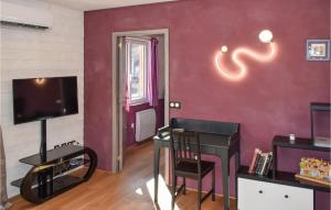 ein Wohnzimmer mit einer roten Wand und einem TV in der Unterkunft 1 Bedroom Amazing Home In Calavant 