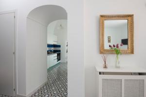 a kitchen with white walls and a mirror at Casa del Duca in Amalfi