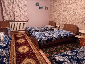 Habitación con 3 camas y alfombra. en Kausar, en Karabulak