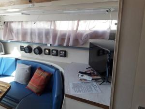 a small room with a blue couch and a desk at Yacht Stay Providence Marina in Providence