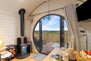 a view from the inside of a caravan with a wood stove at Blaenplwyf Luxury Countryside Shire Pods with Hot Tubs in Lampeter